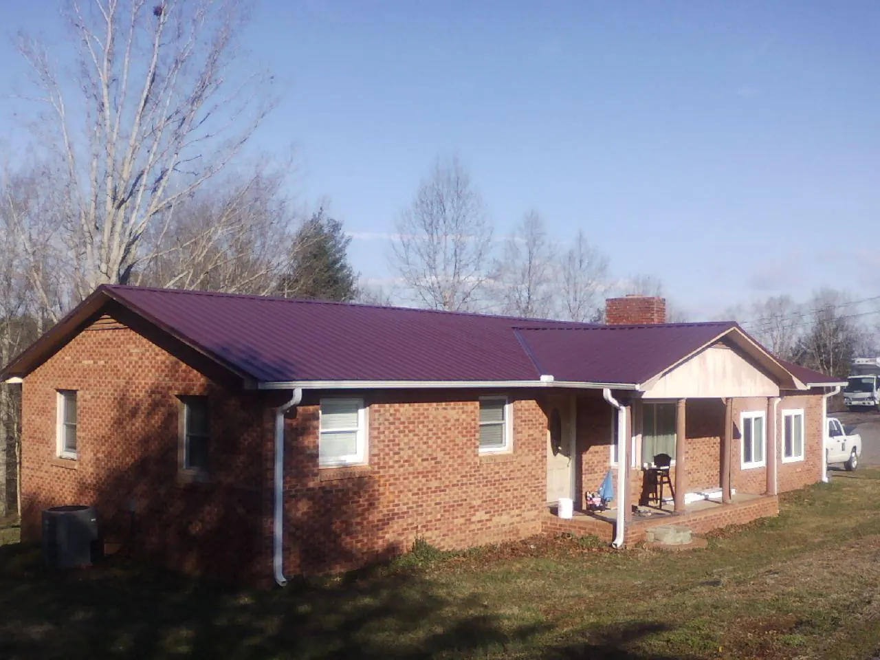 Burgundy metal roof on a brick ranch home with a new addition in Aumsville