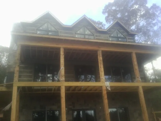 Dormers and porch framing on a large log home under construction — Roof Coating work by our crew in Aumsville